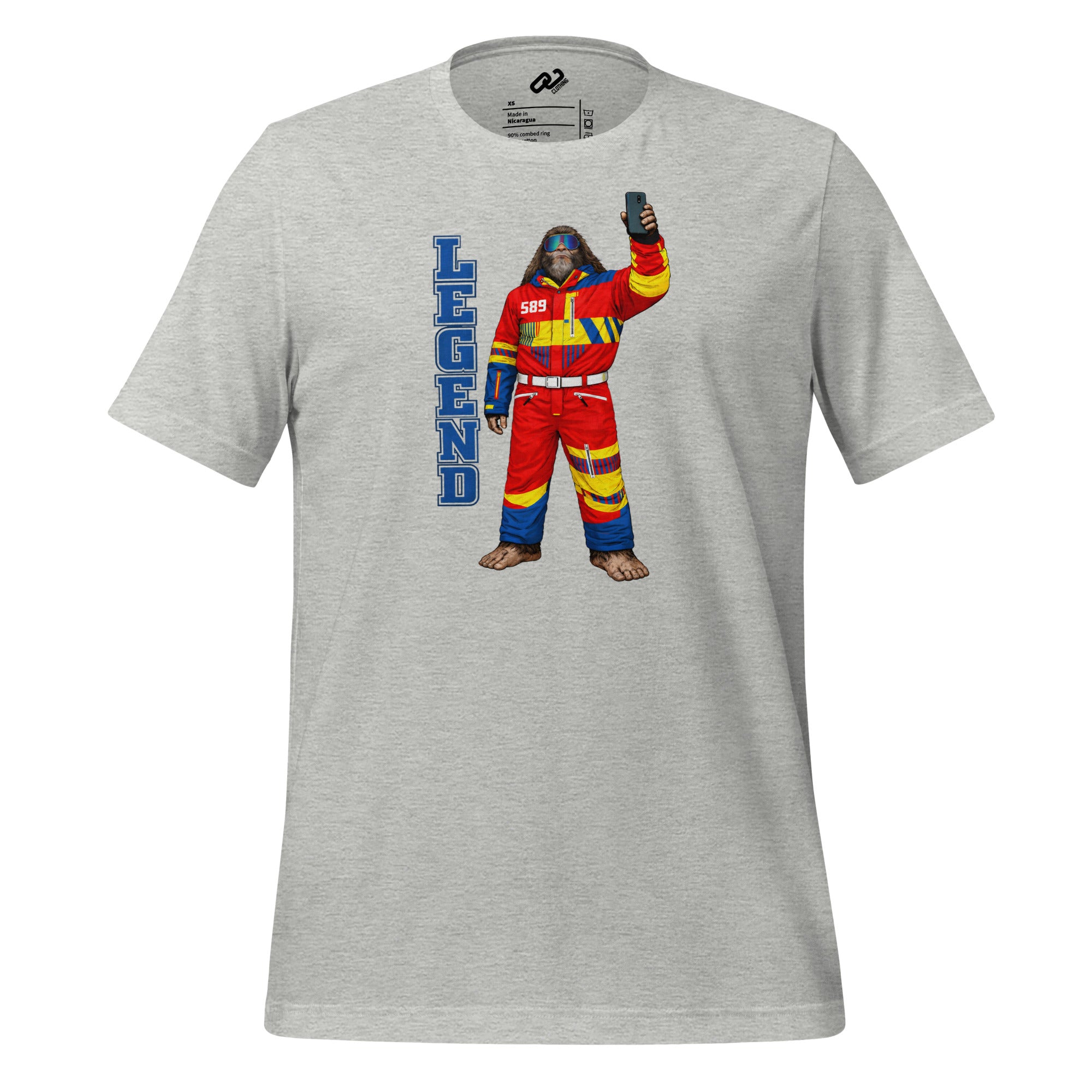 Grey t-shirt that says legend in blue block letters and a yeti dressed in a red ski suit with a 589 emblem on the front, ski glasses and holding up a phone taking a selfie.